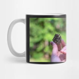 Hand holding pine cone Mug